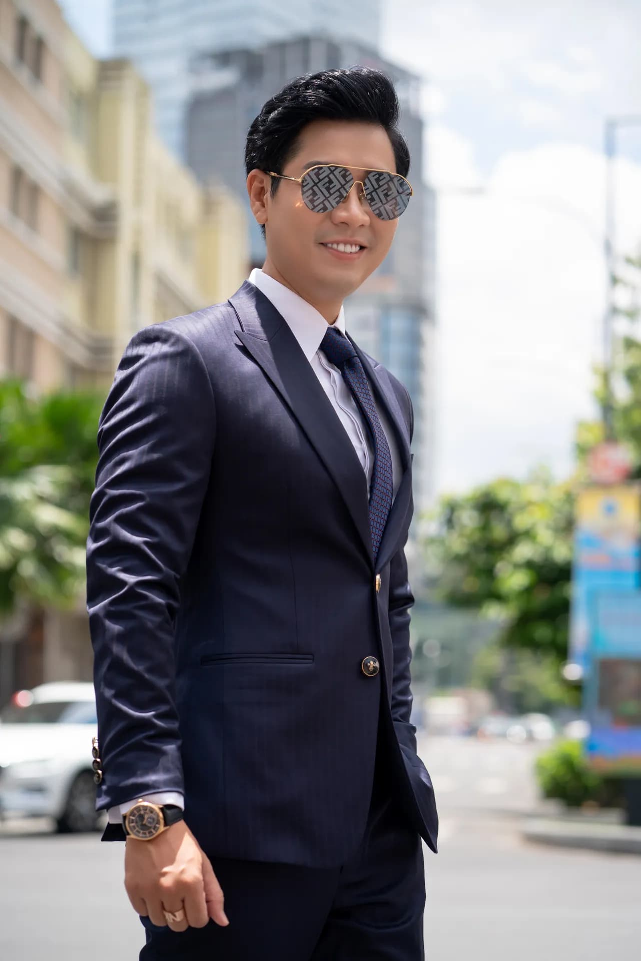 Suit xanh navy, kính râm, nghiêng người cận cảnh giữa phố