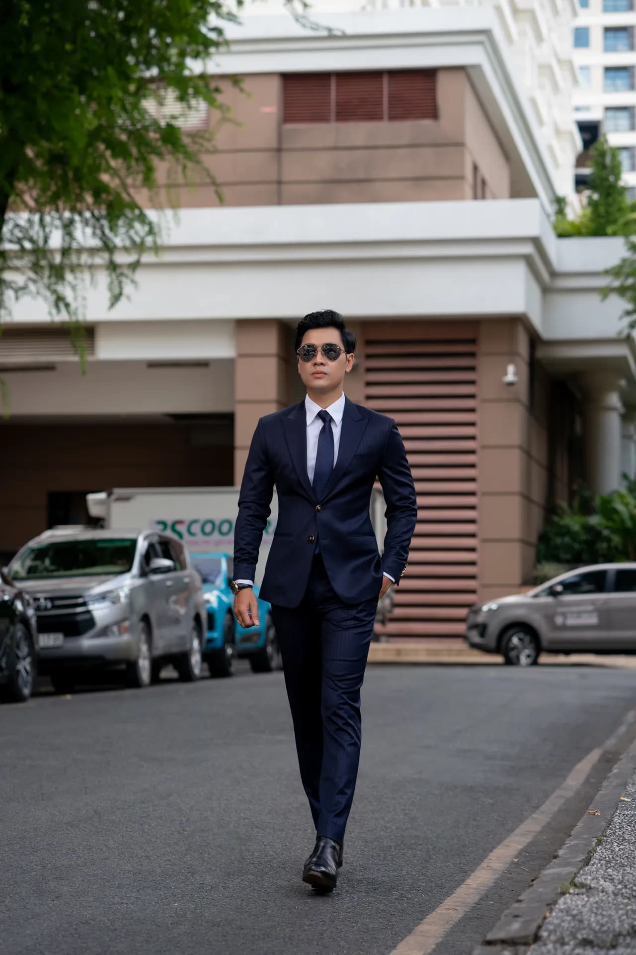 Suit xanh navy sải bước giữa phố, nền tòa nhà cổ