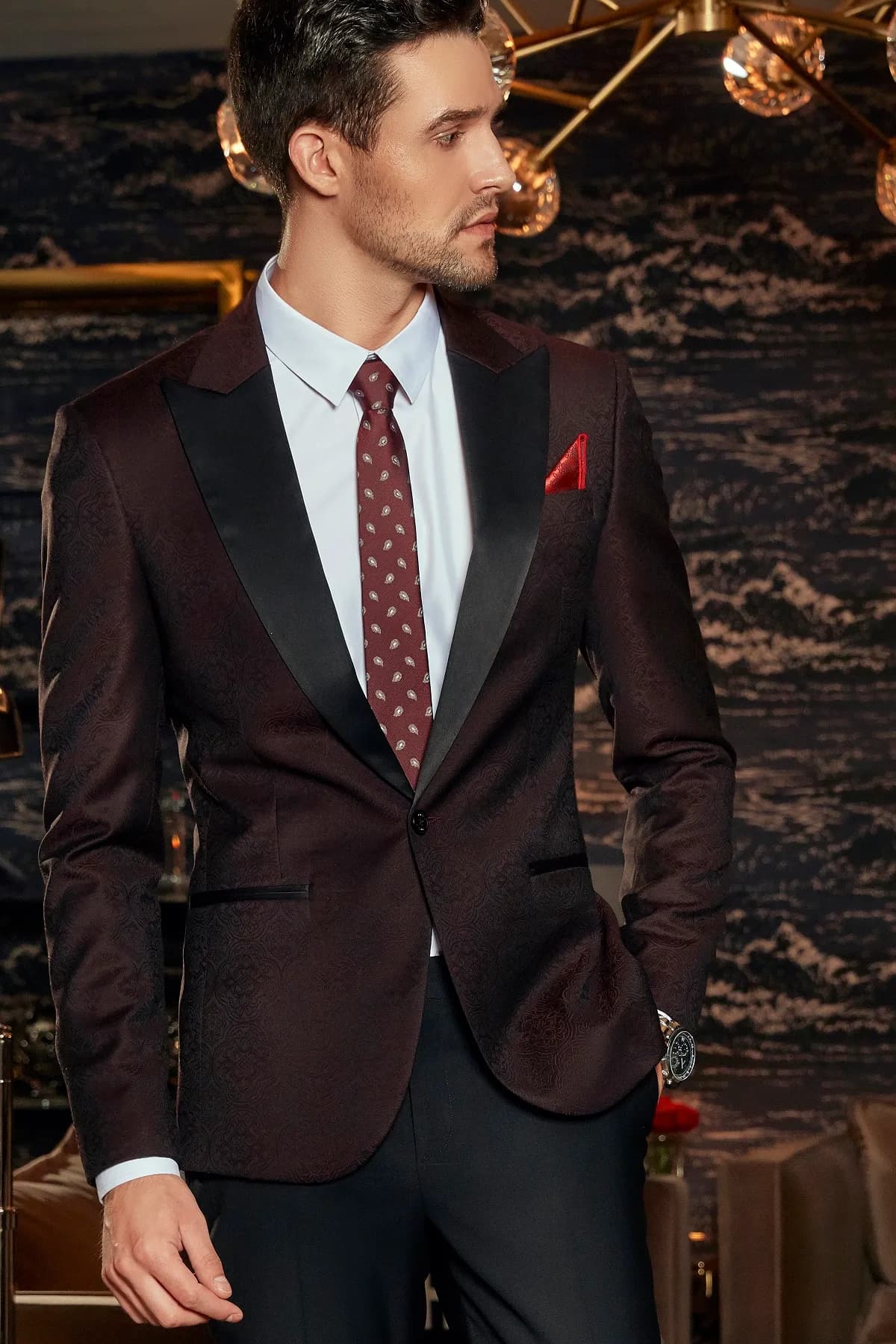 Blazer đỏ rượu ve satin, khăn cài túi đỏ, cận cảnh dưới đèn pha lê