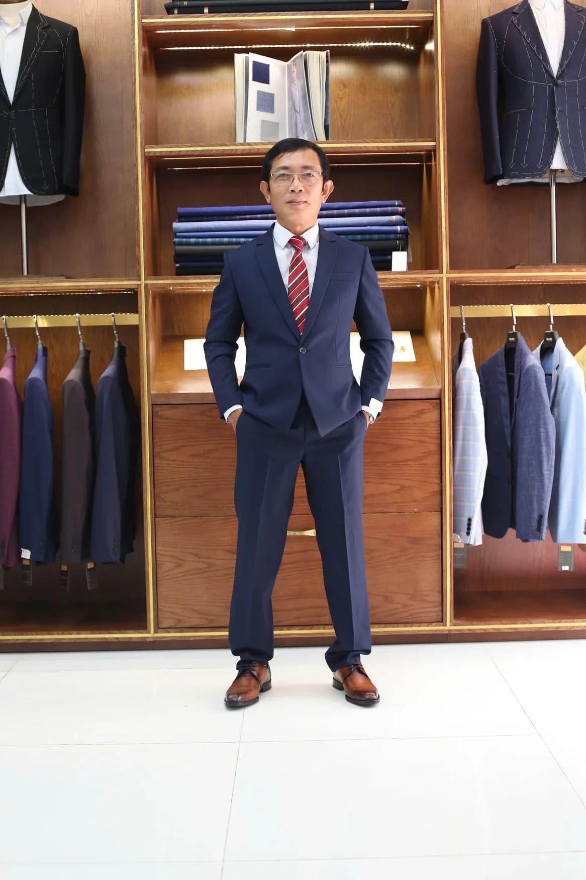 Quý ông đeo kính, vest navy, cà vạt sọc đỏ