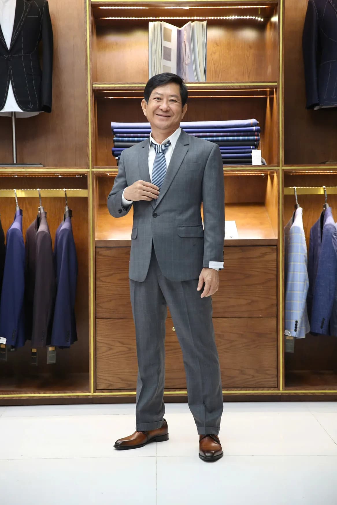 Quý ông vest xám, cà vạt sọc xanh, dáng đứng thanh lịch
