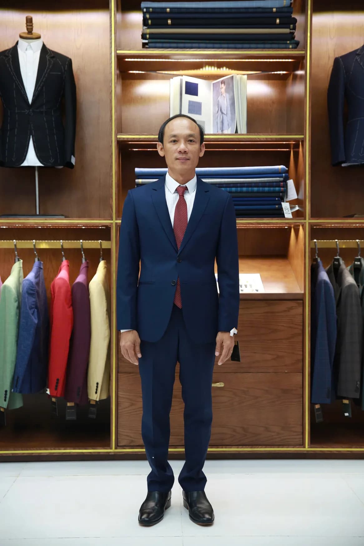 Người đàn ông vest xanh navy, cà vạt đỏ chấm bi