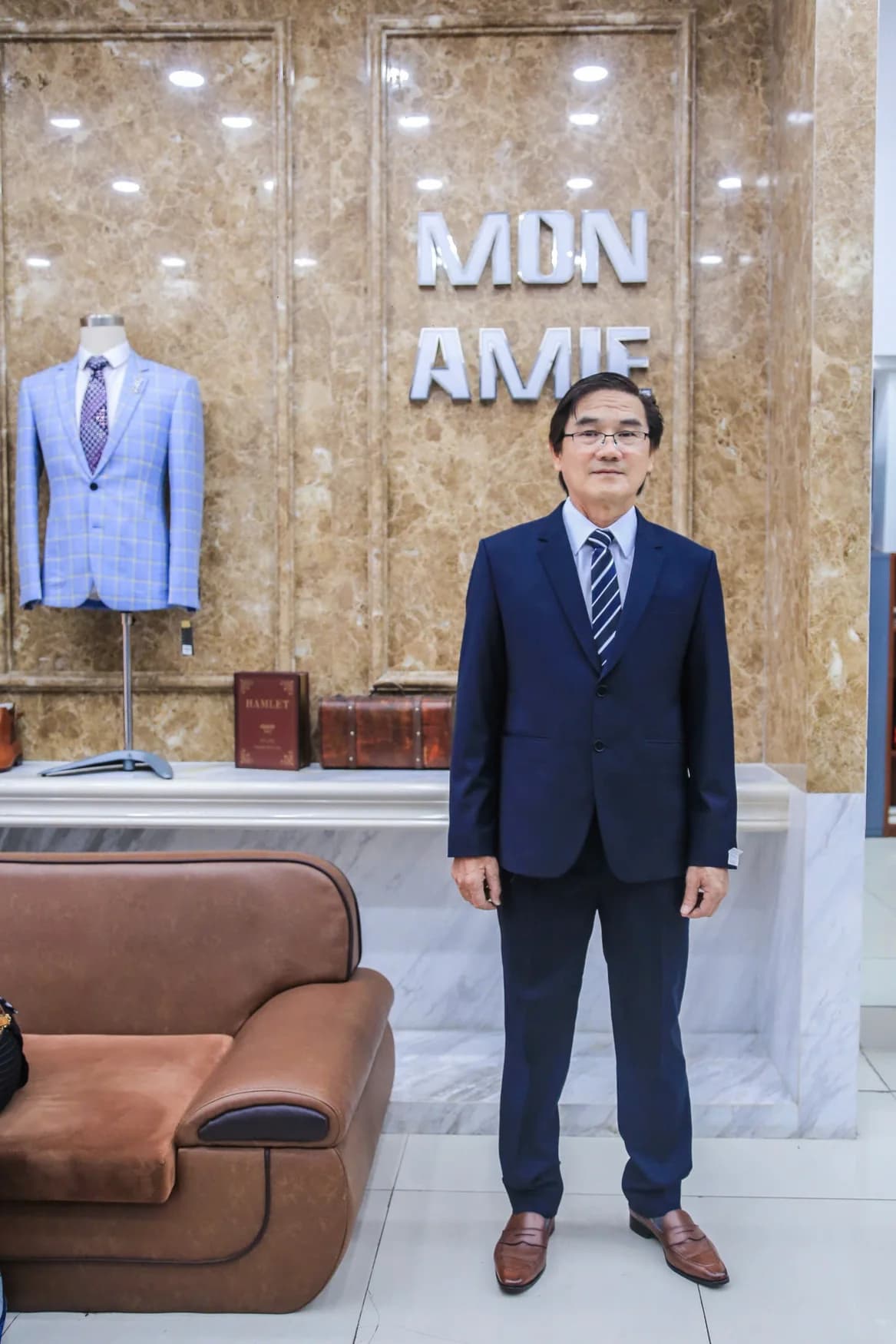 Quý ông vest navy, giày nâu, nền đá cẩm thạch