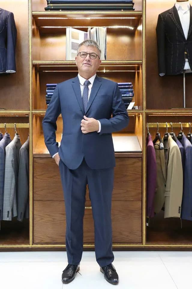 Quý ông trung niên vest xanh navy, kính, cà vạt tím