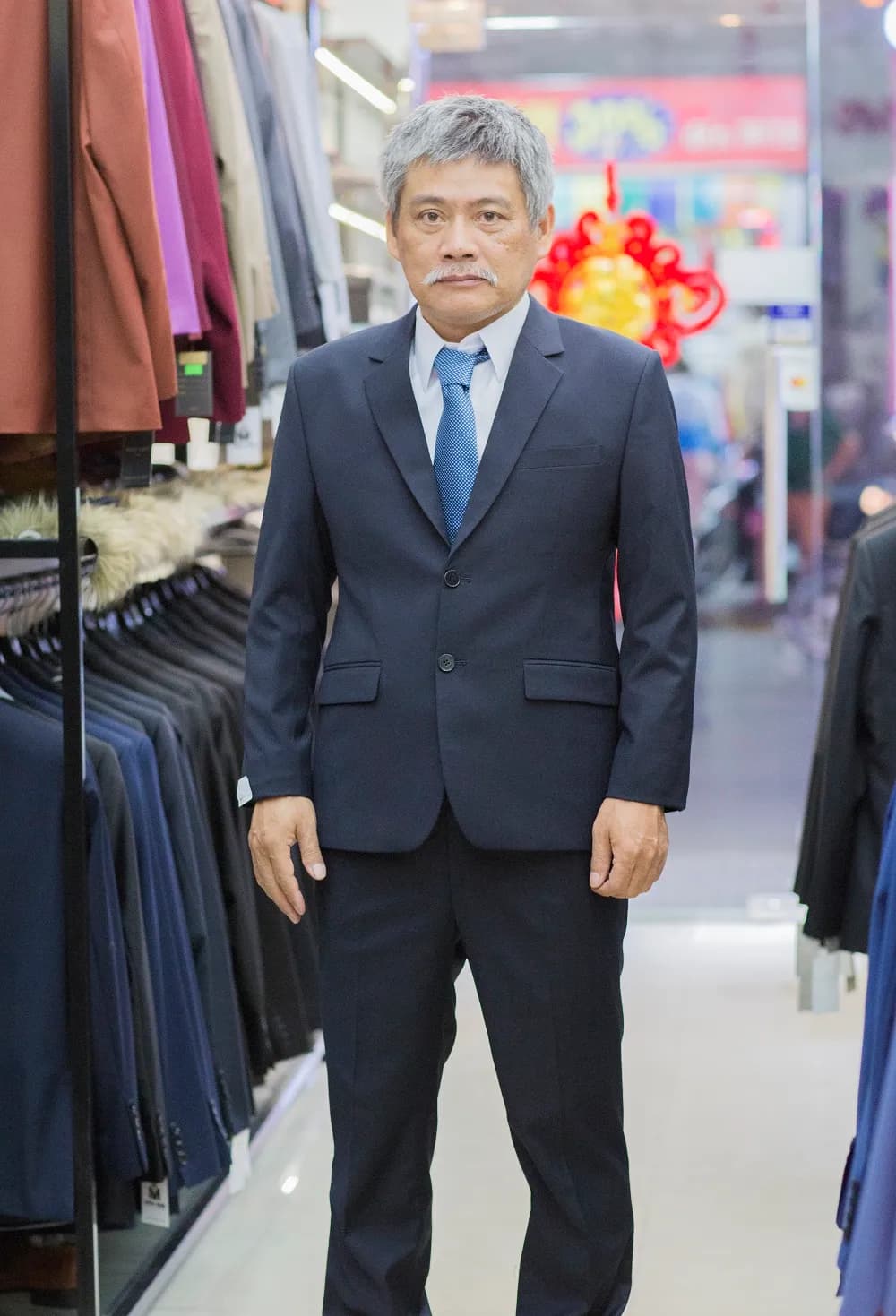 Suit xanh navy hai cúc phối cà vạt xanh chấm bi, dáng chỉnh chu, trang trọng