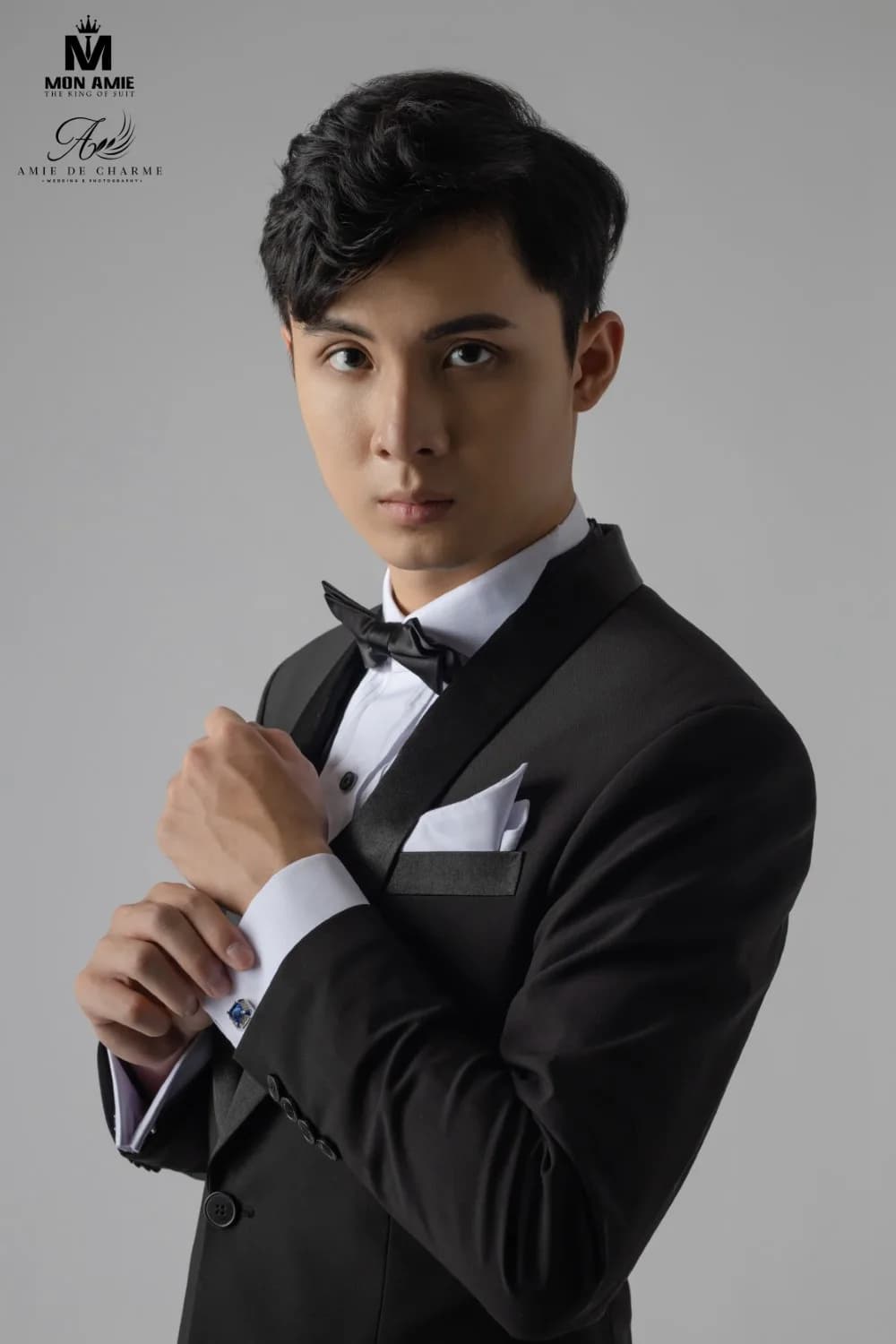 Cận cảnh tuxedo đen: ve satin, nơ đen, khăn cài túi và khuy măng sét