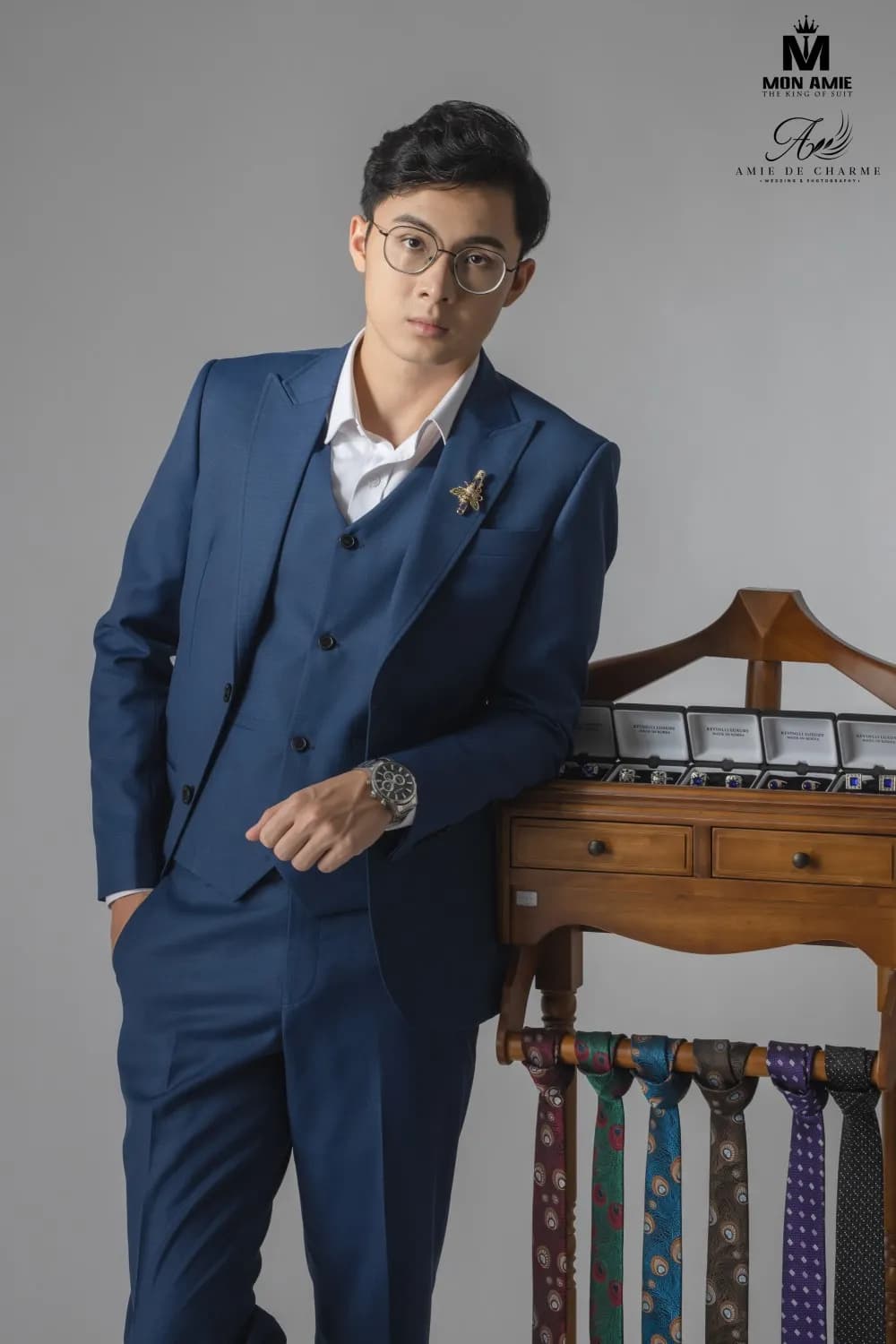 Suit ba mảnh xanh, kính tròn, tựa giá treo cà vạt gỗ cổ điển