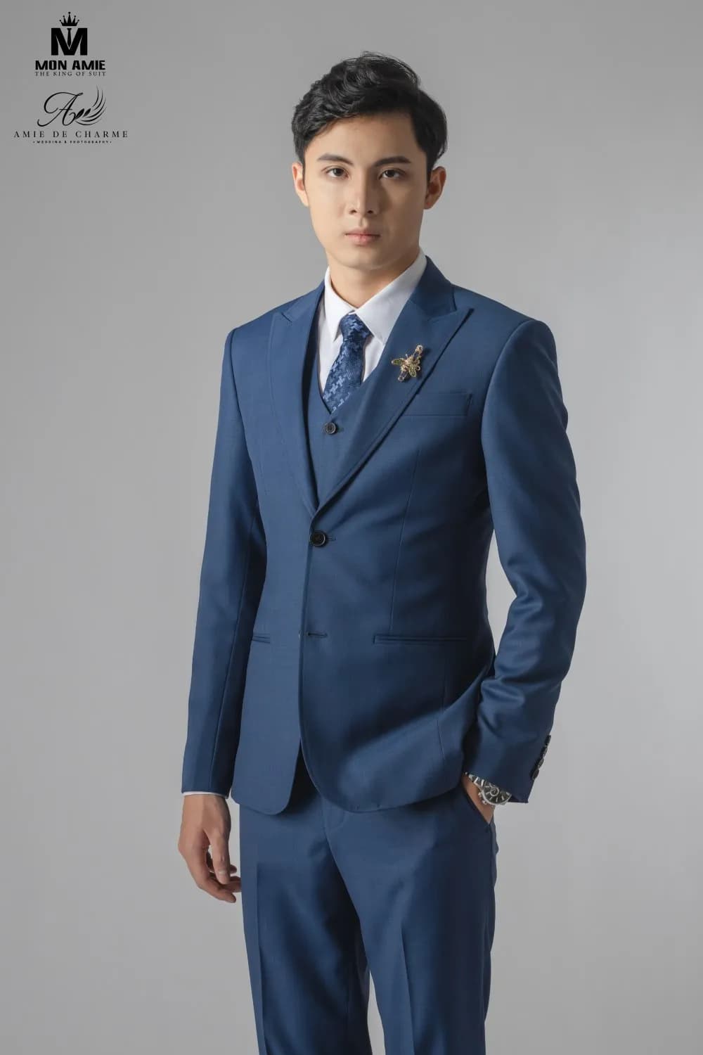 Suit xanh navy hai khuy, ghim cài hình ong, nhìn thẳng ống kính
