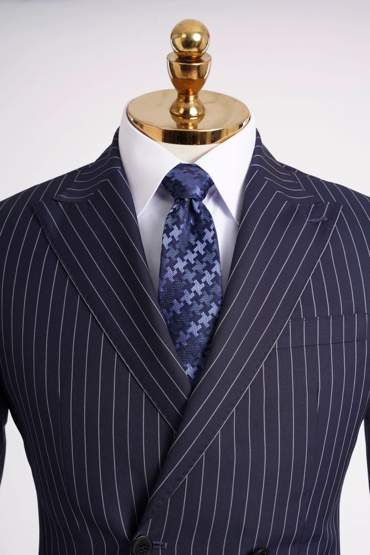 Cận cảnh suit navy kẻ sọc cài hai hàng, cà vạt họa tiết