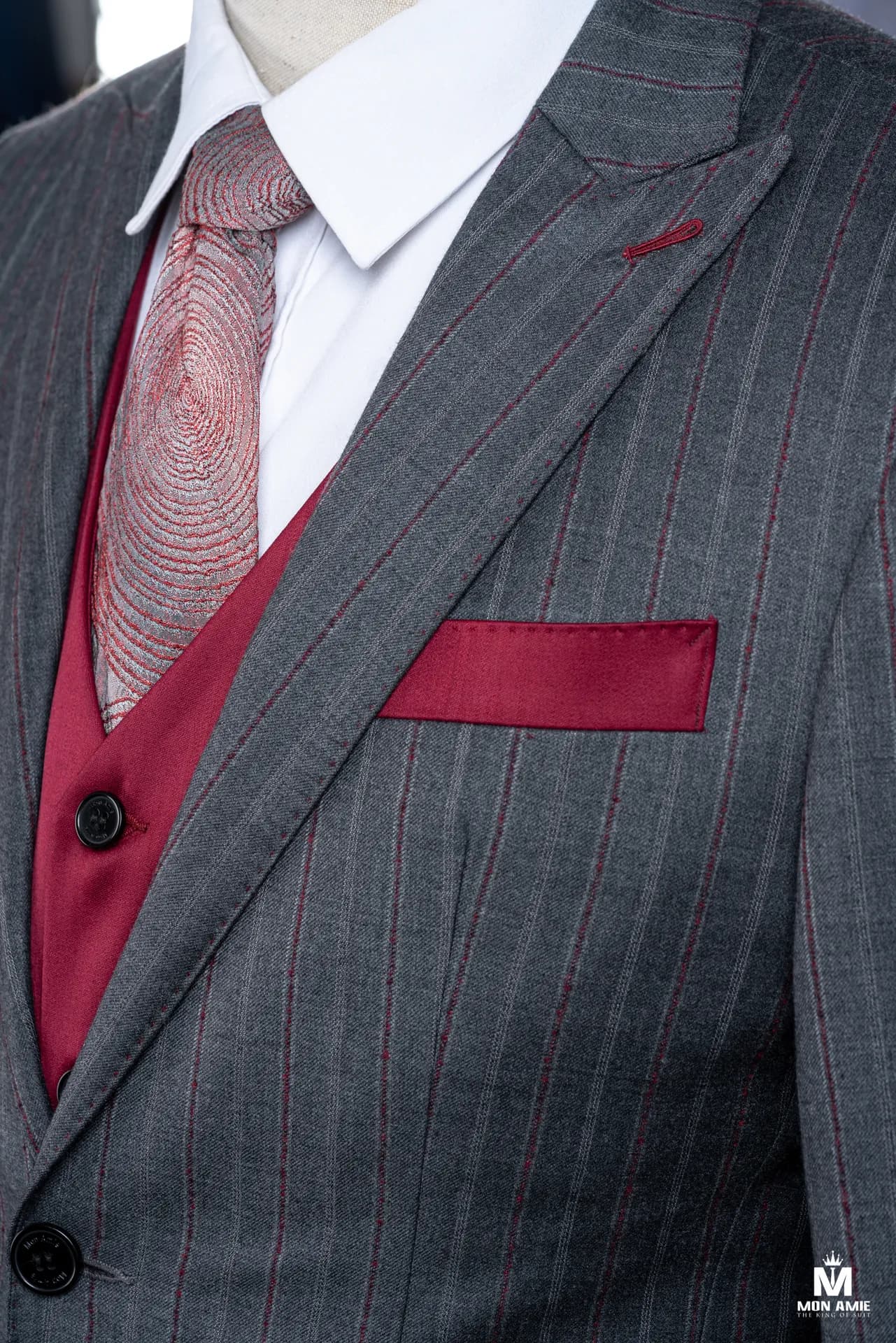 Cận cảnh gile đỏ đô và khăn túi dưới ve nhọn suit xám