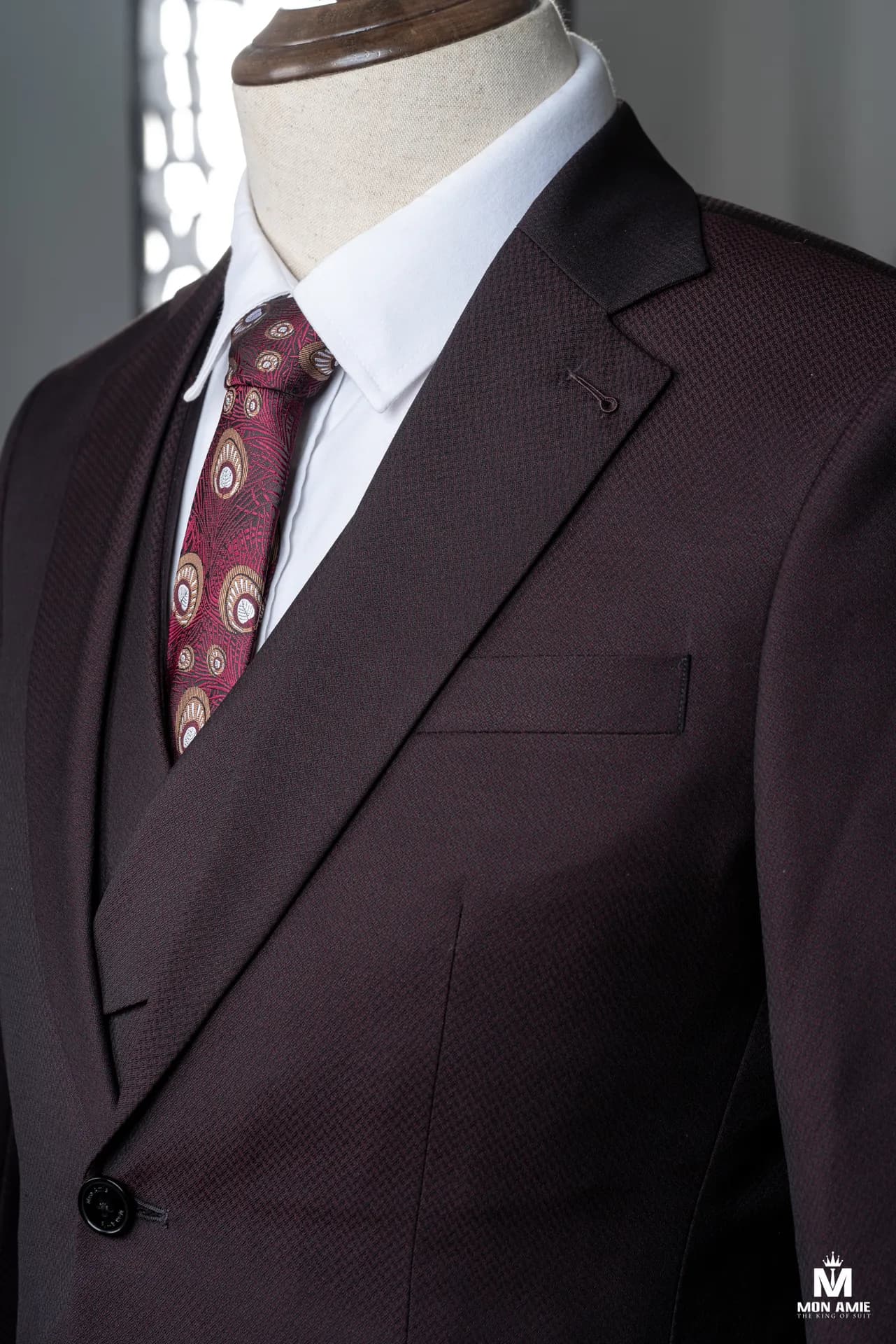 Cận cảnh ve áo suit nâu đỏ, cà vạt họa tiết và sơ mi trắng