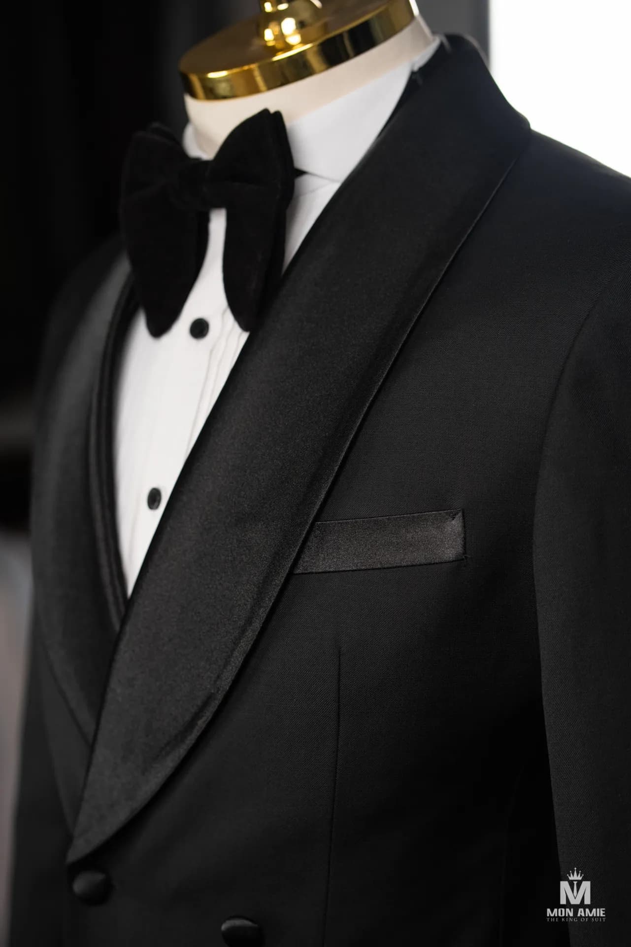 Cận cảnh cổ shawl satin tuxedo đen, nơ bản lớn và khuy măng sét