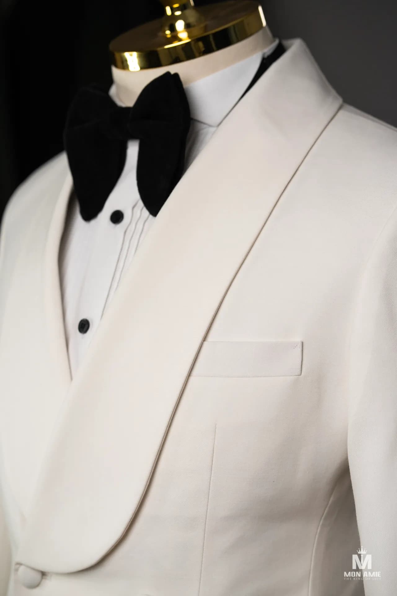 Cận cảnh ve shawl tuxedo trắng ngà, nơ đen và khăn túi