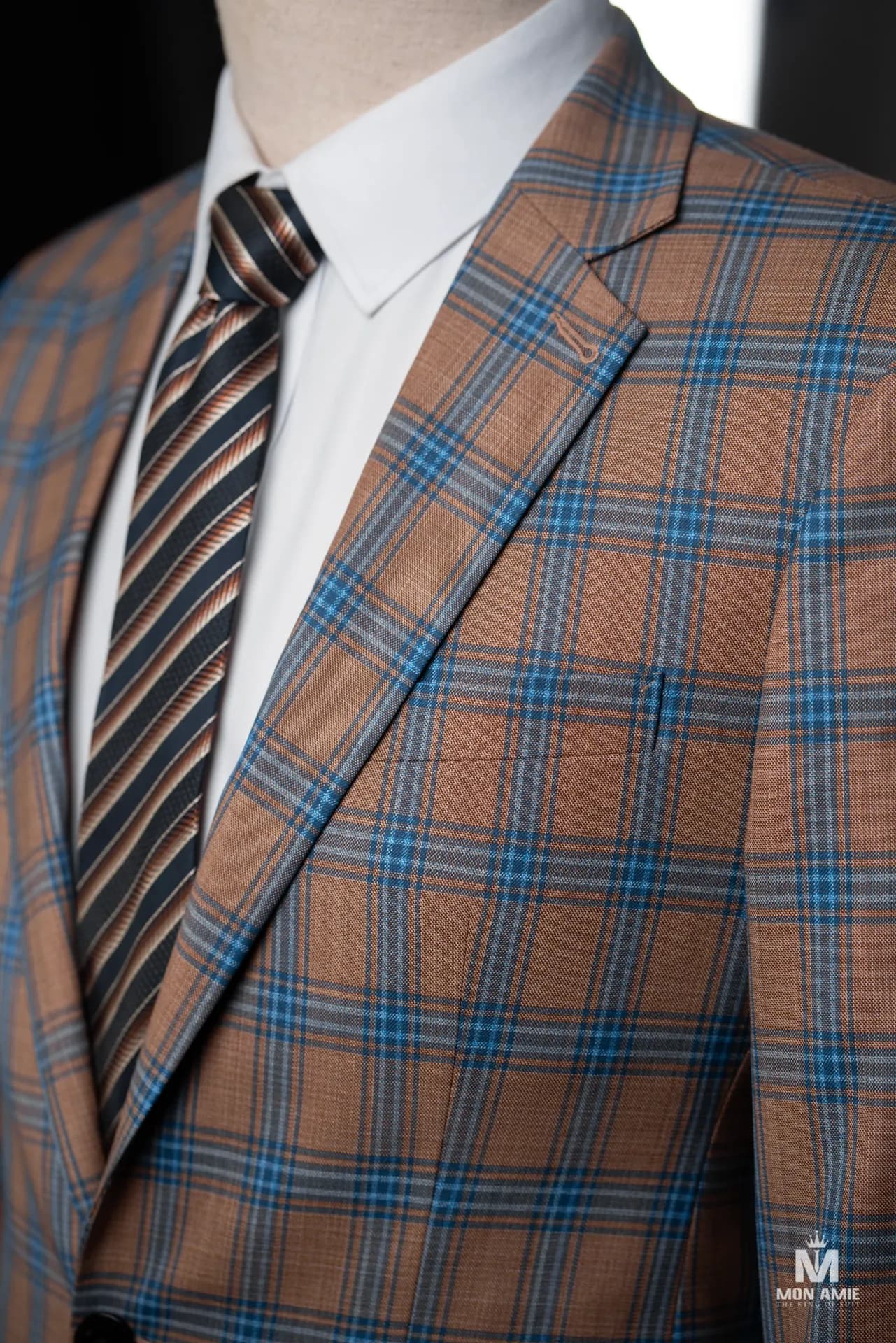 Cận cảnh blazer ca-rô nâu xanh, cà vạt sọc nâu be