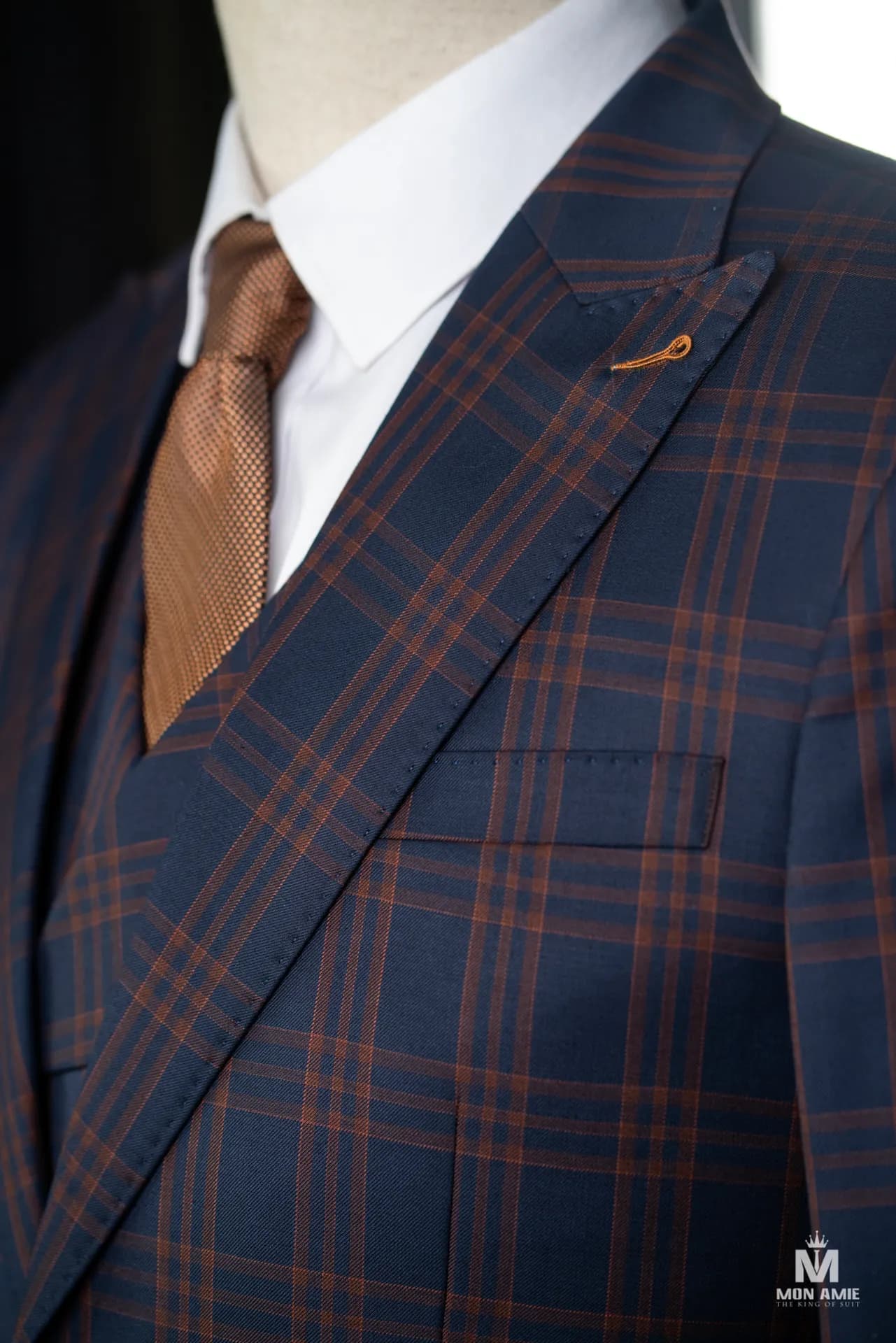 Cận cảnh suit navy ca-rô cam, ve nhọn và cà vạt nâu