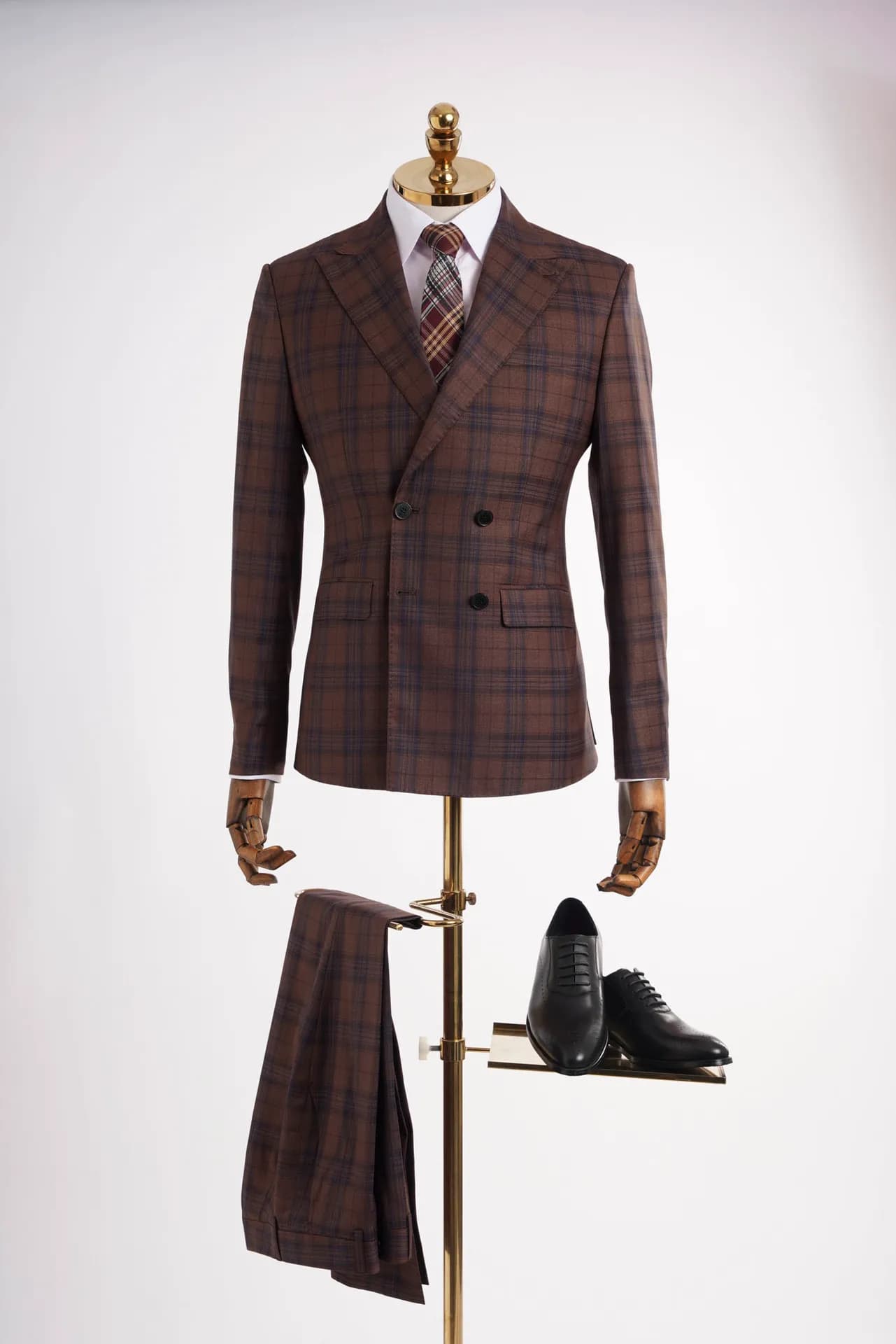 Suit nâu kẻ ca-rô cài hai hàng, phối giày da và quần tây trên mannequin