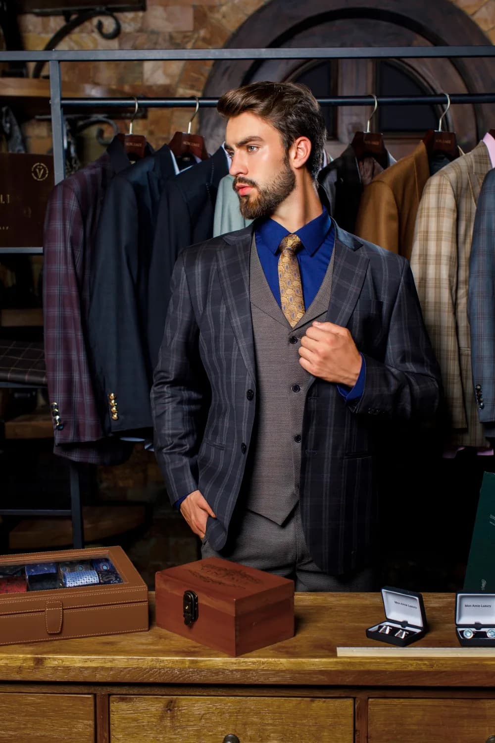 Suit caro xám kèm gilê ghi, sơ mi xanh đậm và hộp phụ kiện gỗ