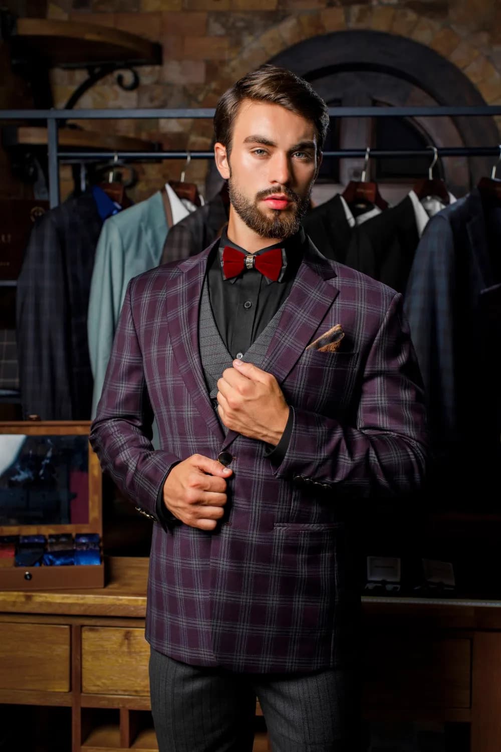 Suit kẻ ô tím, nơ đỏ rượu, khăn cài túi, trong xưởng may đo