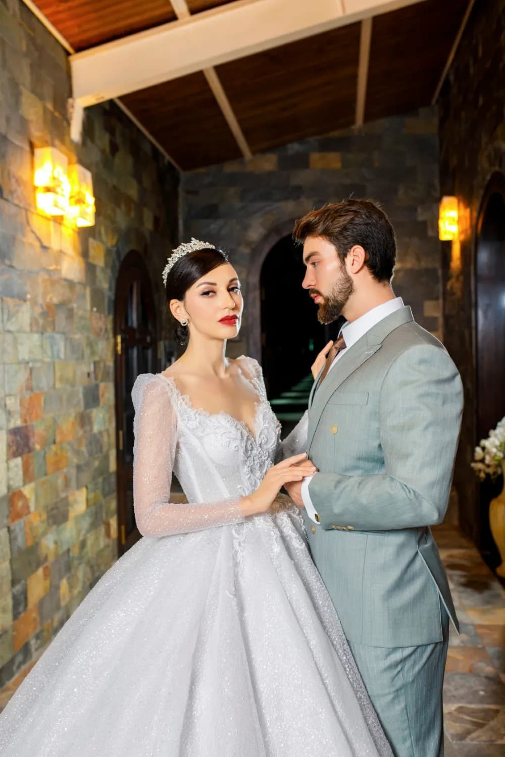 Chú rể suit xanh bạc hà bên cô dâu váy xòe lấp lánh trong sảnh đá