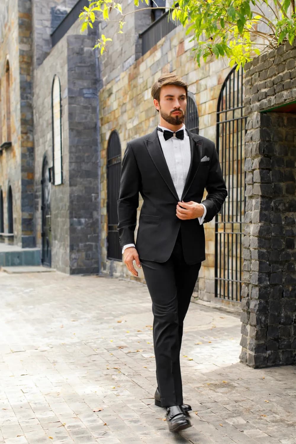 Tuxedo đen thắt nơ, sải bước trên con đường lát đá
