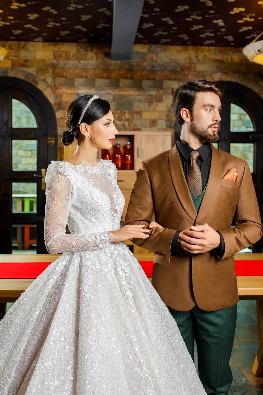 Chú rể blazer nâu quần xanh lục bên cô dâu váy ren lấp lánh