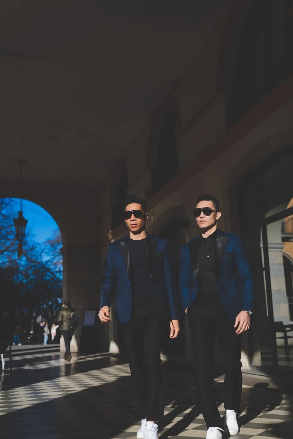 Bộ suit caro be bên váy cưới xòe giữa sân đá, tông ấm hài hòa