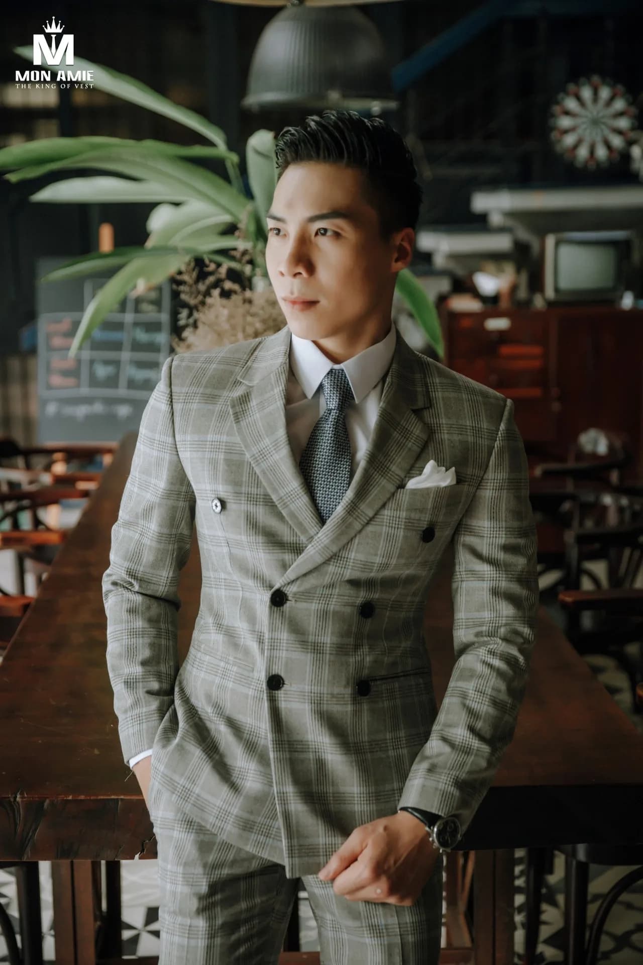 Suit caro xanh, quần nâu đỏ trên bậc thang đá bên váy cưới đuôi dài