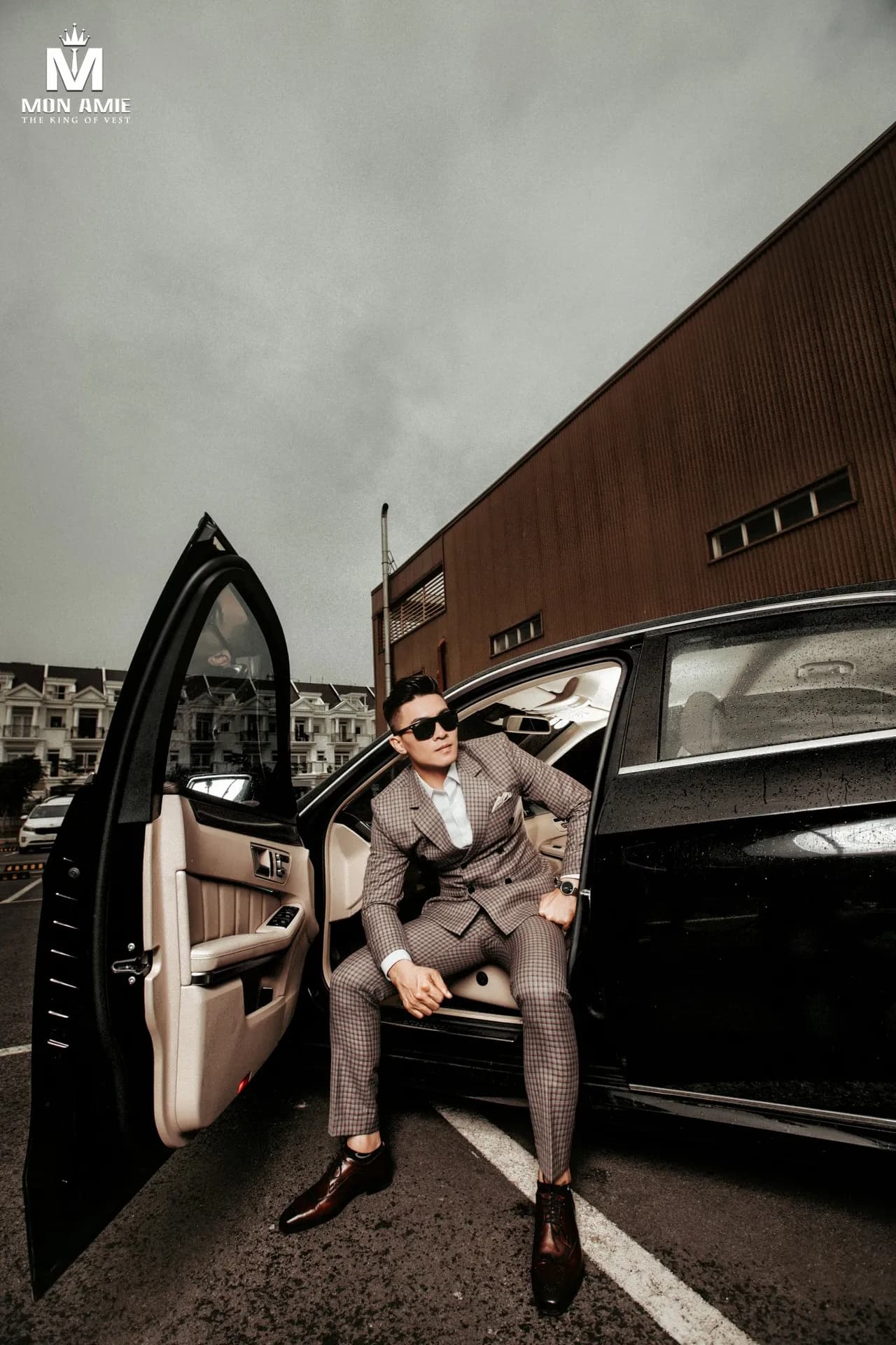 Suit kẻ caro nâu hai hàng khuy, kính râm, bước xuống chiếc sedan đen
