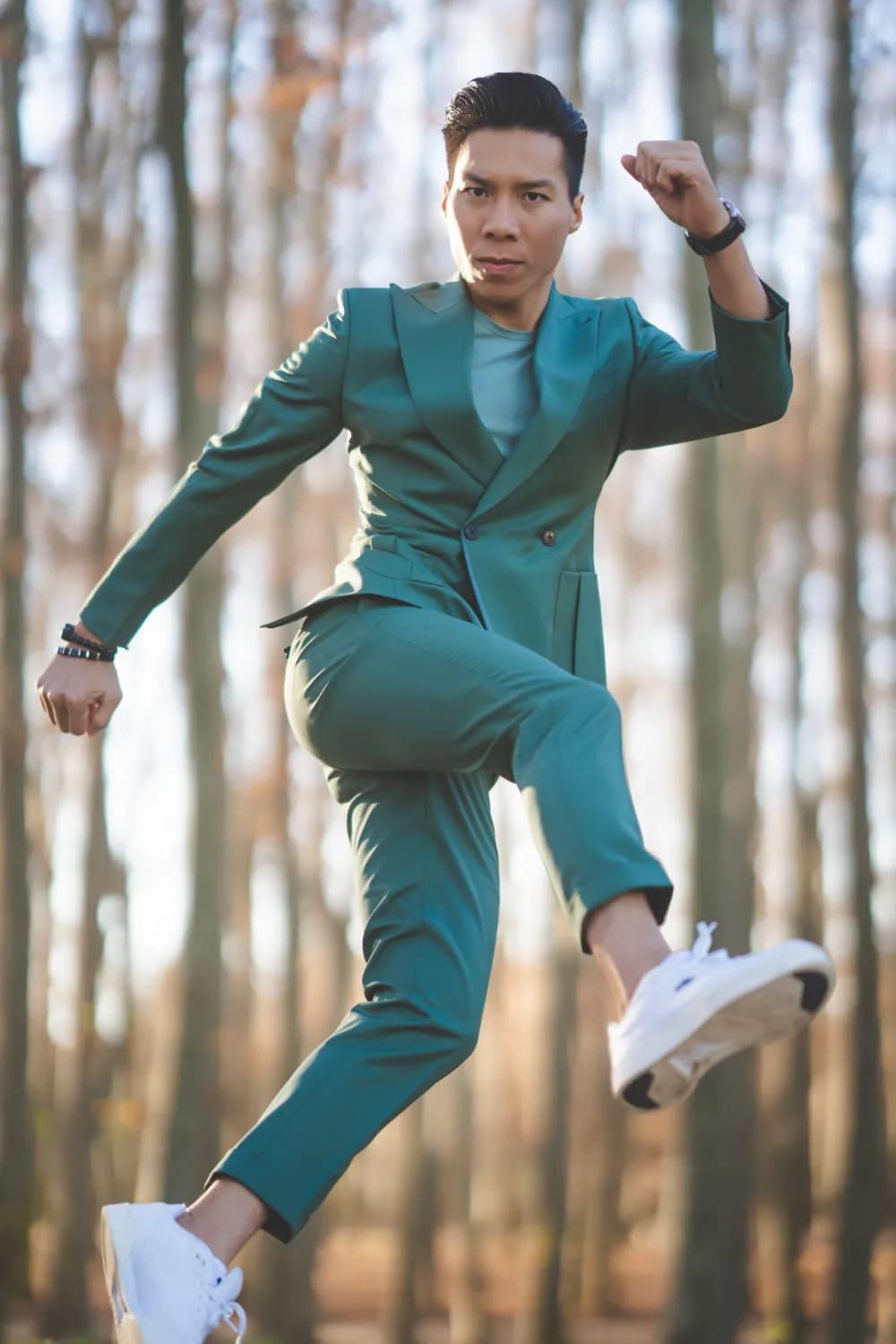 Suit hai hàng khuy xanh lục, sneaker trắng, bật nhảy giữa rừng cây mùa thu