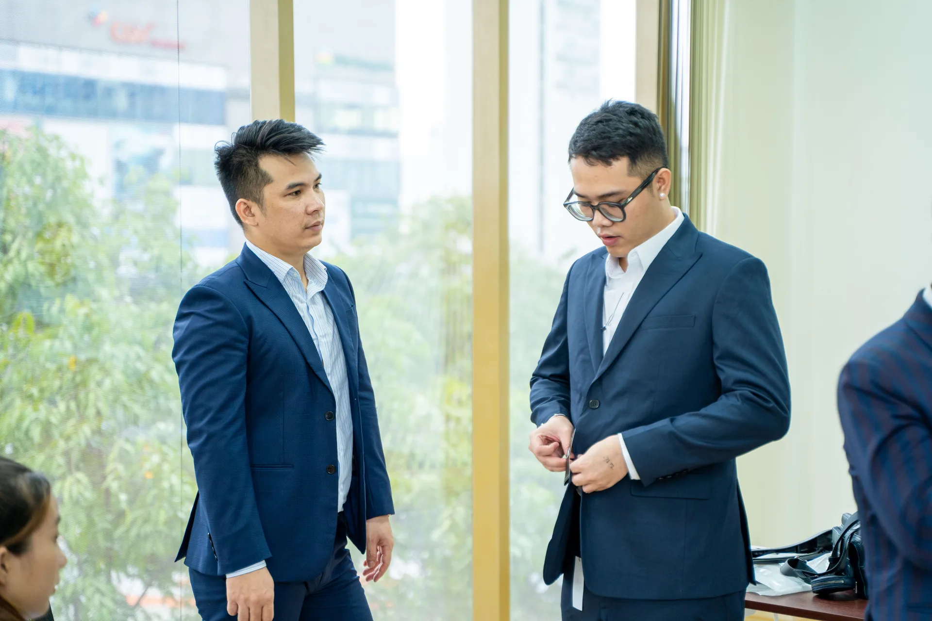 Nhân viên nam thử vest xanh navy, đối chiếu form sau khi nhận đồng phục
