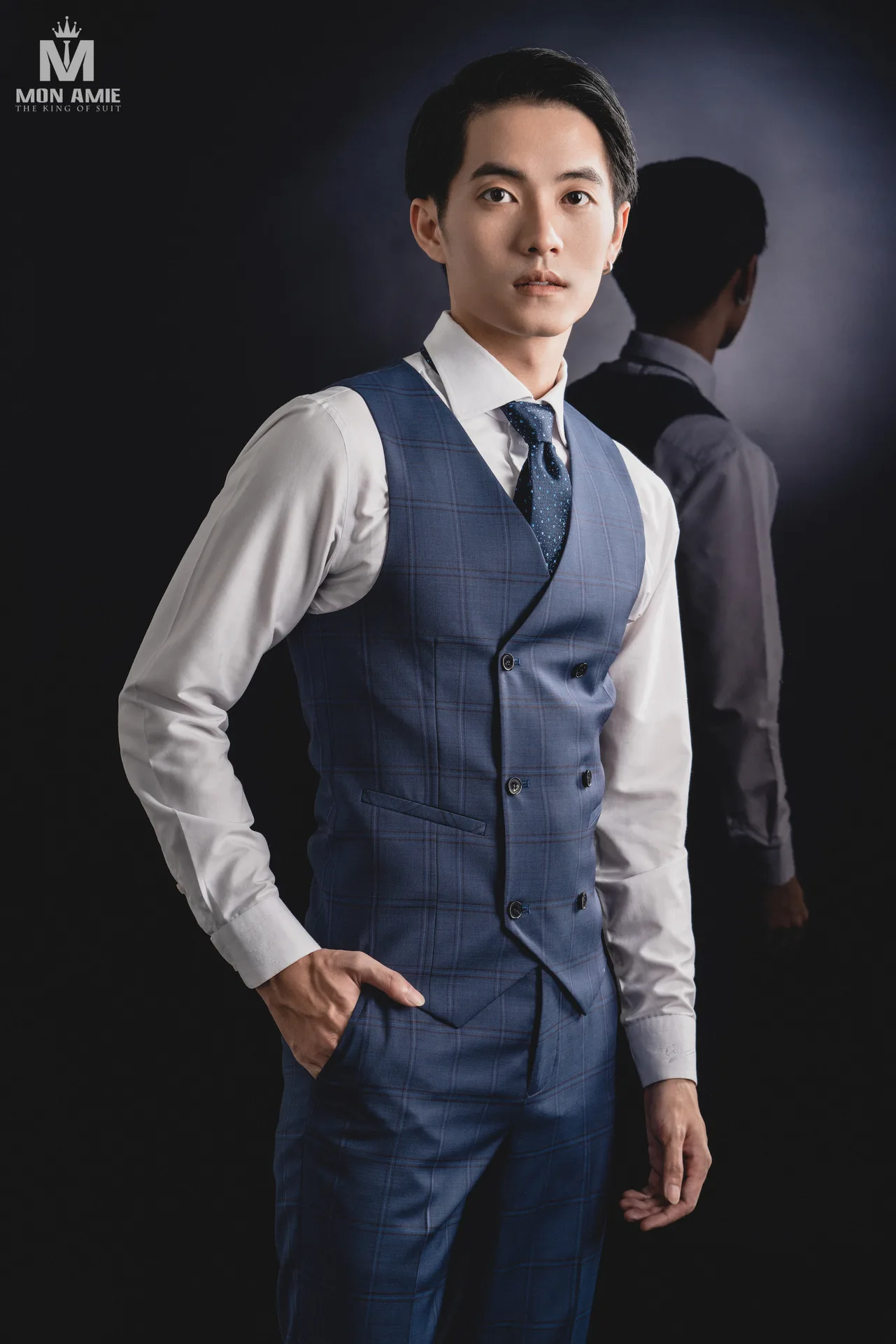 Blazer đen hai hàng khuy phối cà vạt sọc đỏ trước tường đá, ví dụ vest đen cà vạt đỏ có họa tiết