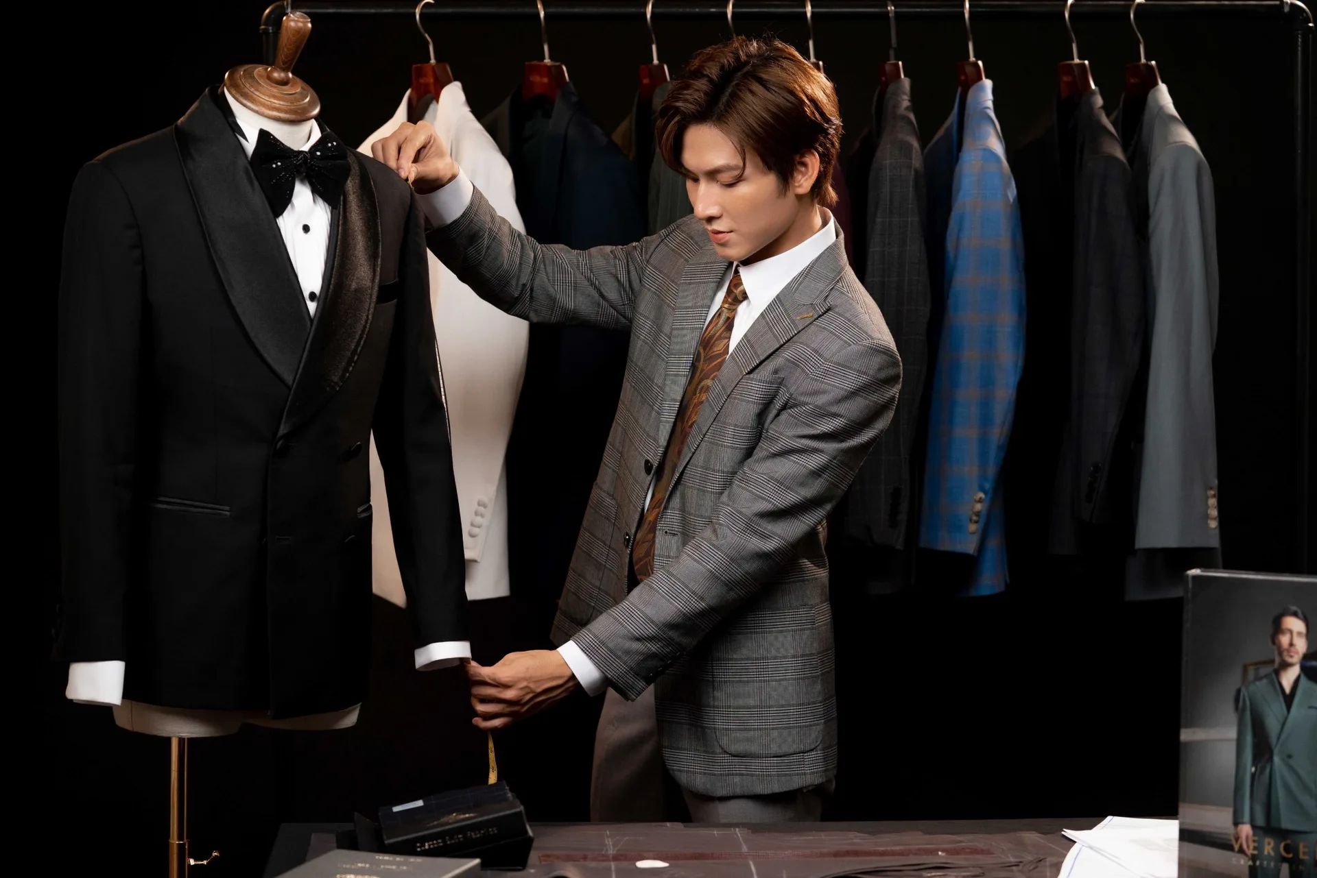 Chỉnh tay áo tuxedo đen trên mannequin, khoảnh khắc thợ may hoàn thiện bộ vest cưới