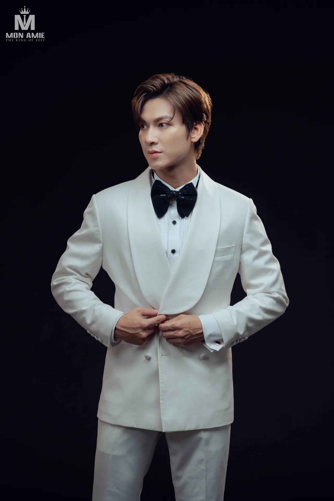 Tuxedo trắng cổ ve shawl, nơ đen nổi bật trên nền tối