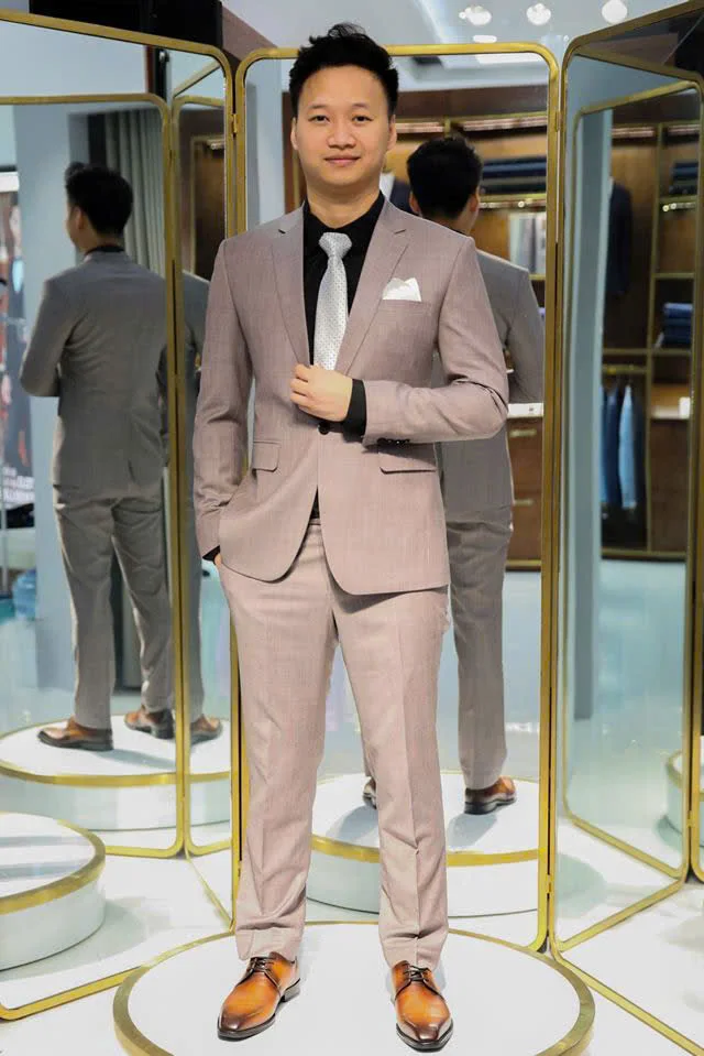 Man in a dusty pink suit, silver tie and patina brown shoes