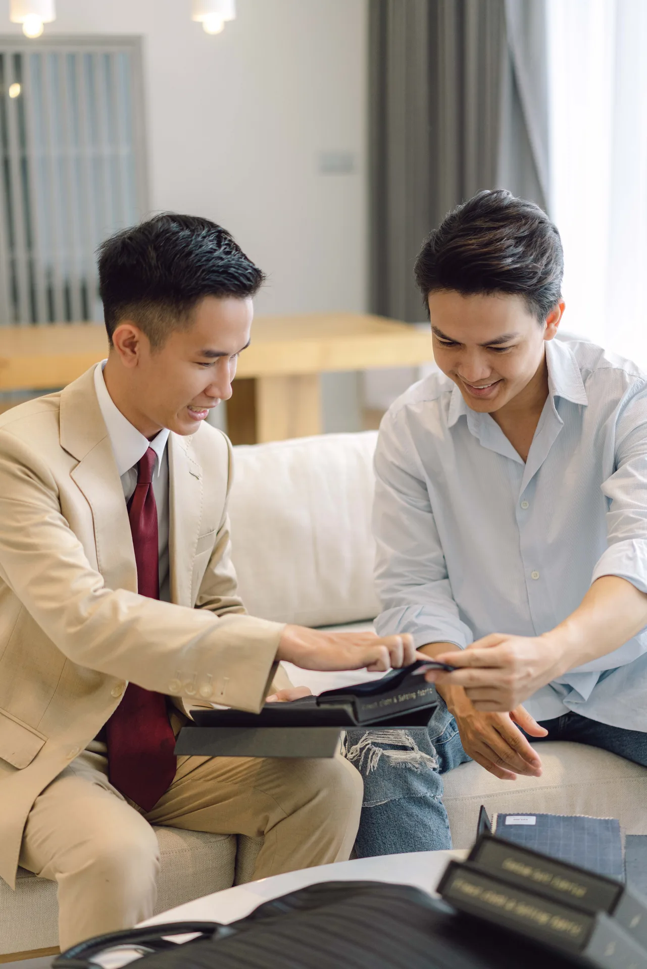 Nghệ nhân mở tập vải, cùng khách chọn chất liệu tại phòng khách, hình thức may đo vest nam tại nhà