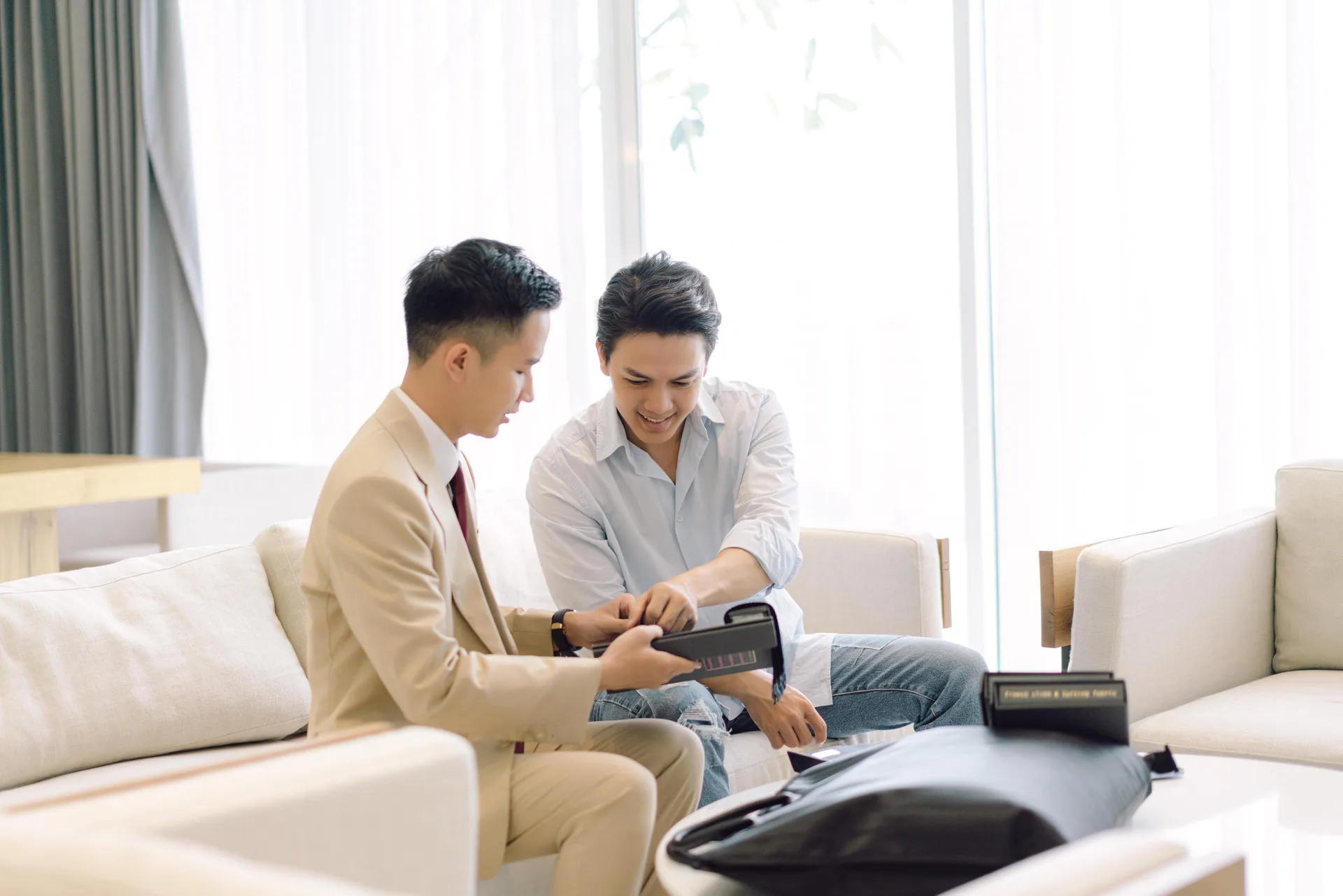 Buổi tư vấn vải trong phòng khách ngập nắng, hai bên cùng xem tập mẫu, minh họa chọn vải wool theo thực tế