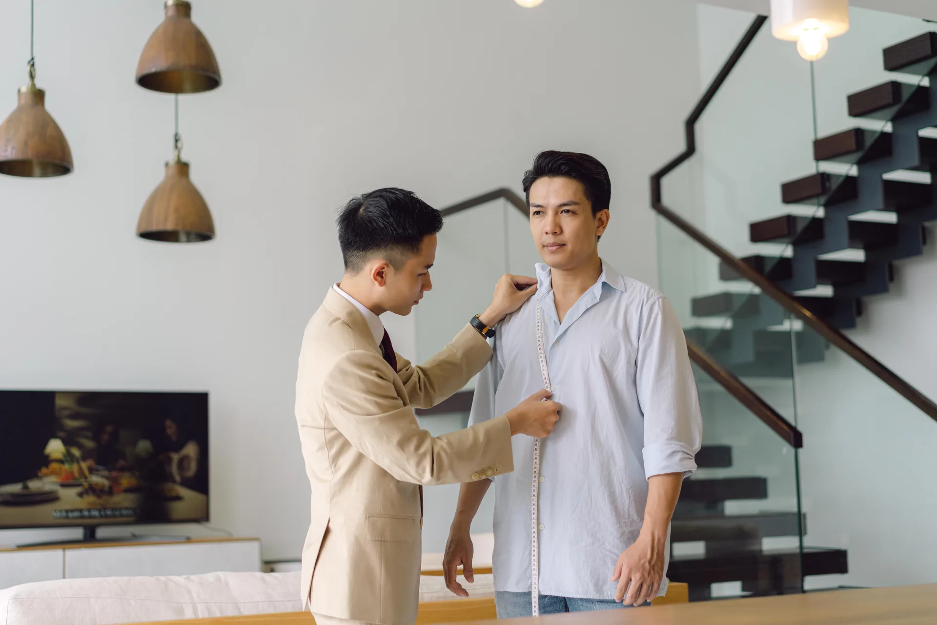 Nghệ nhân đo dài thân áo cho khách, một trong các số đo quyết định size vest hơn cả cân nặng