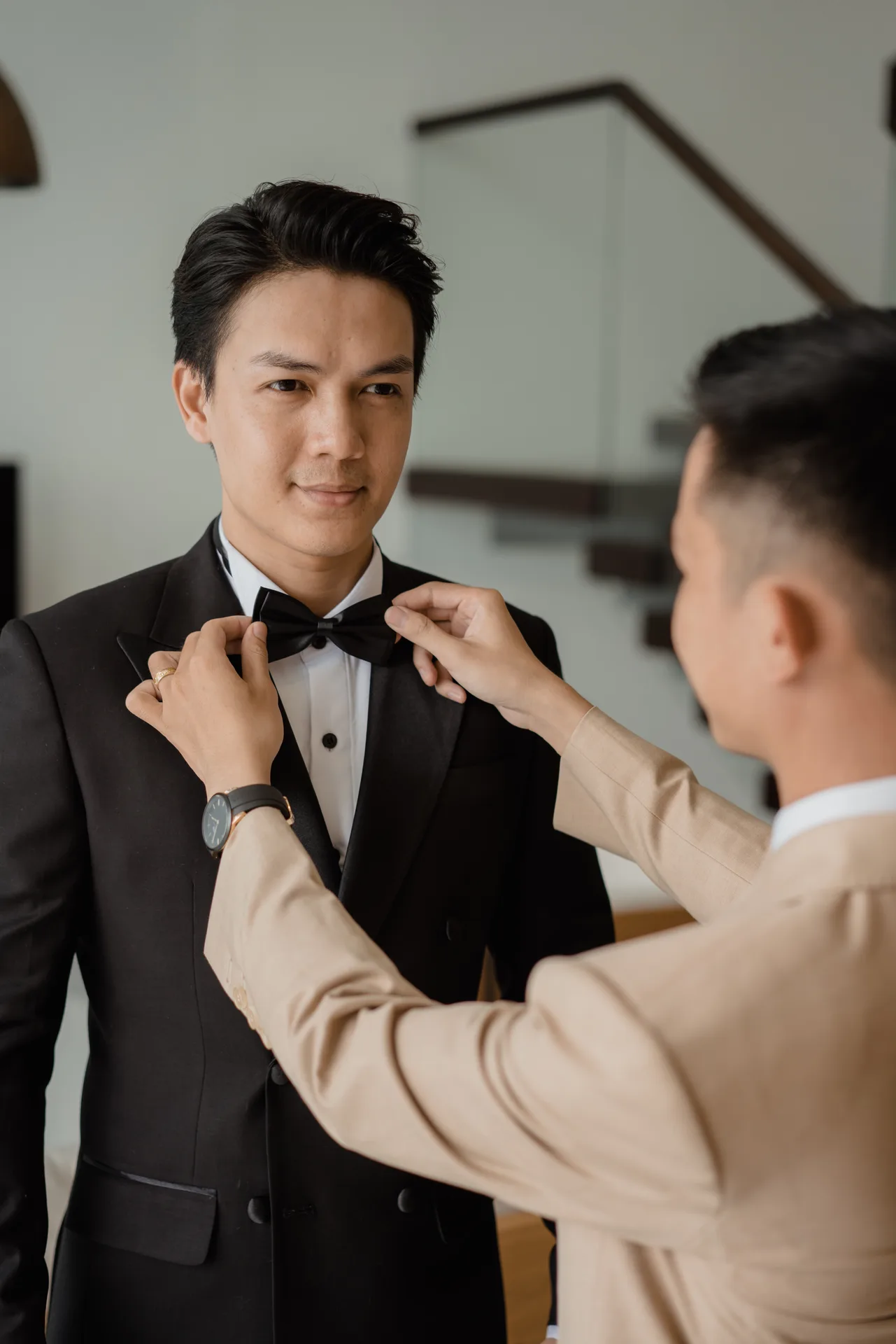 An artisan adjusting a bow tie for a customer, a close-up of careful hands tying a bow tie