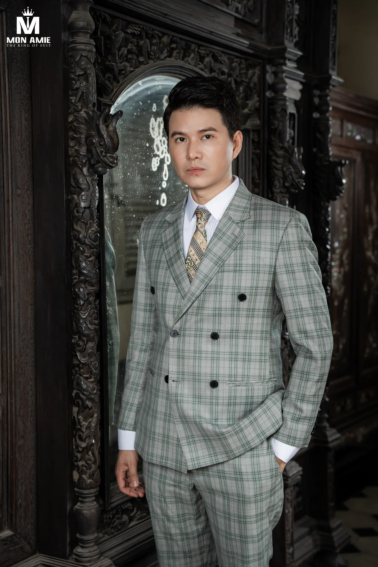 Chi tiết suit caro xanh lá cùng cà vạt hoạ tiết, nền gỗ chạm