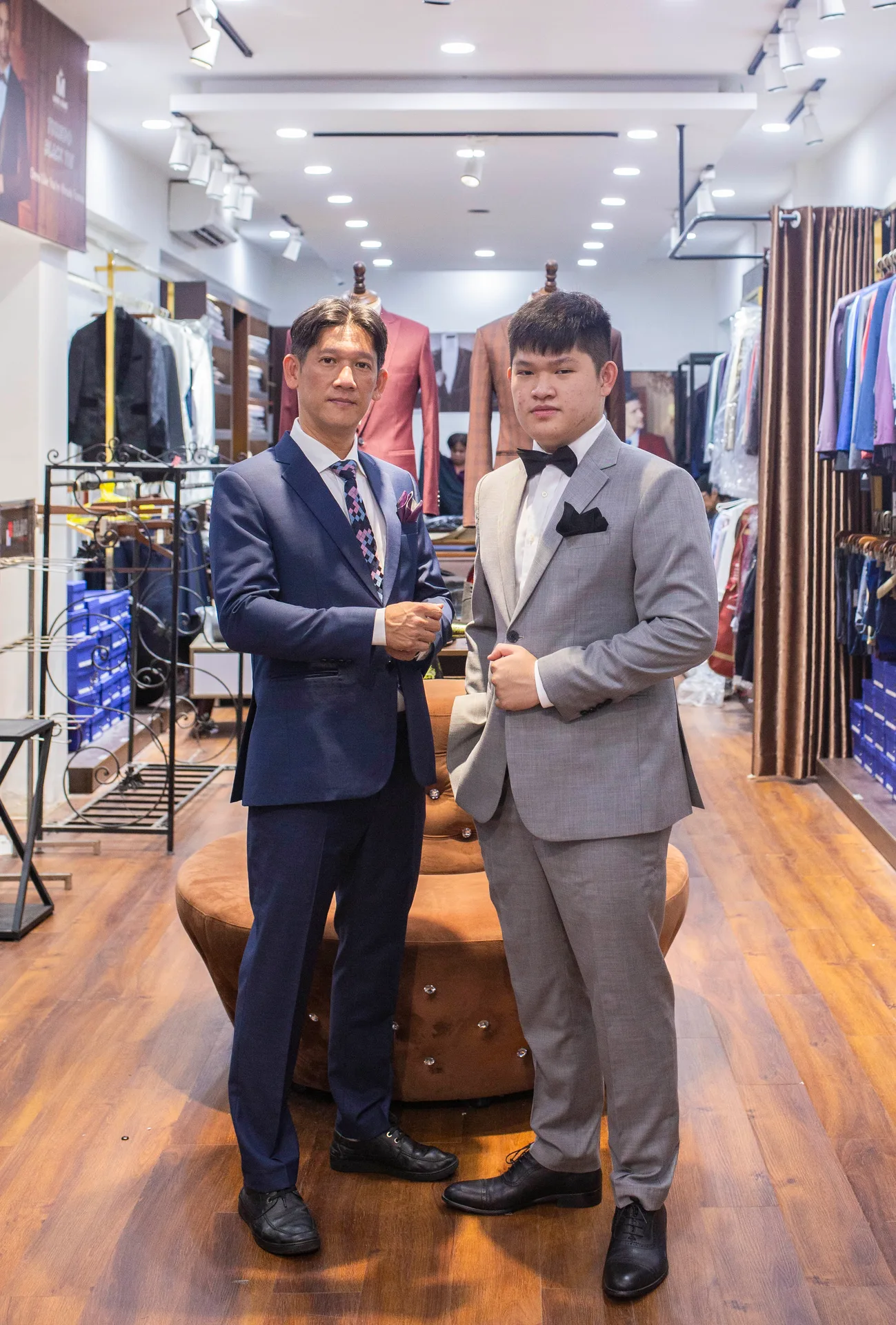 Father and son in a navy suit and a grey suit with a black bow tie, a model of colour coordination between the groom and his father