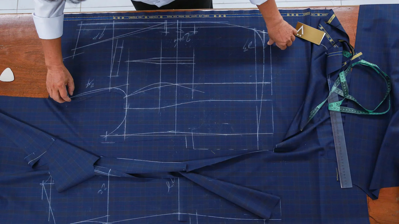 Nghệ nhân trải vải len navy đã vẽ phấn rập, khâu cắt quyết định vest may đo có đúng form hay không